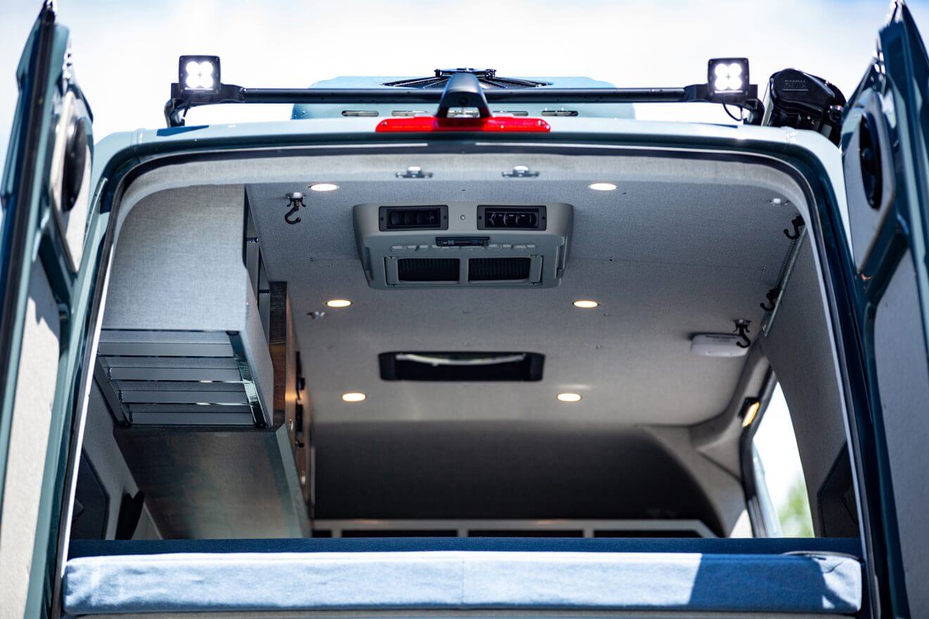 Detail of custom ceiling with lights, fans, and air conditioner in off road sprinter van