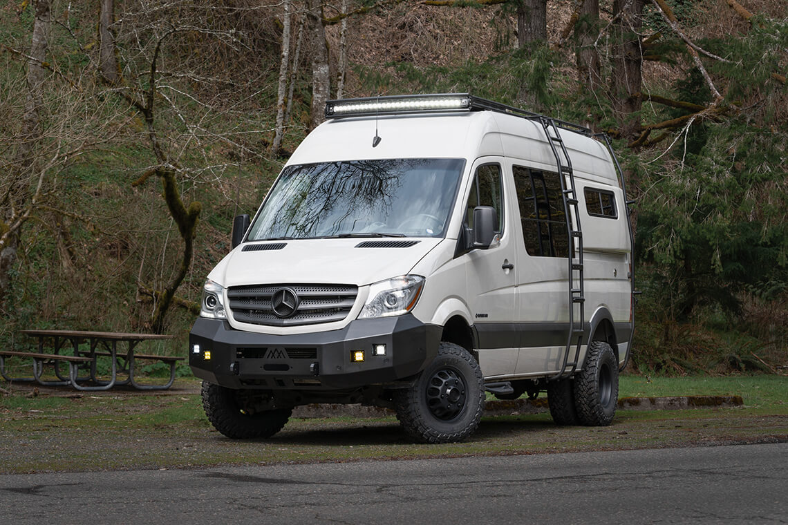 Custom off road mercedes sprinter van parked in dark forest
