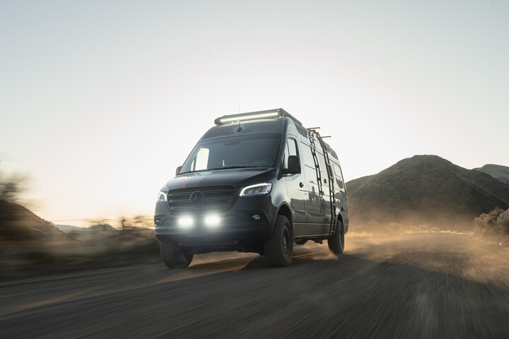 Outside Van Approach model shown driving down dirt road